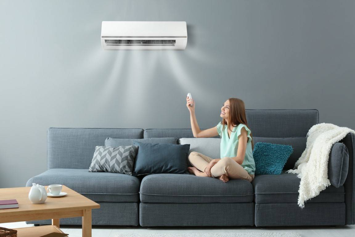Une climatisation murale dans un salon, pilotée par télécommande